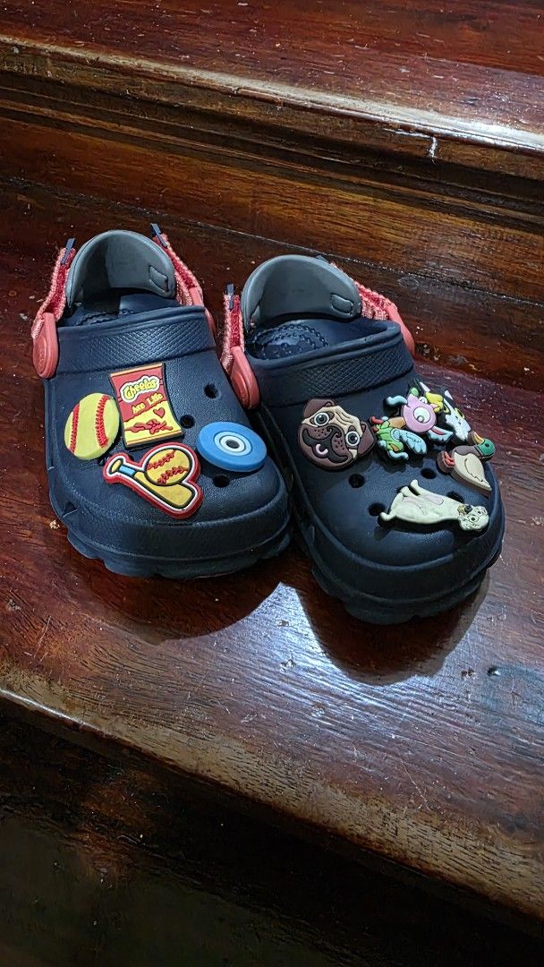 Kids Dark Navy Crocs Clogs with Jibbitz Charms (Category: Babies & Kids Fashion) located in Valenzuela. Submitted by bella_onez (Listing ID 1466445709, Image 1). Description: - Color: Dark navy toddler Crocs - Features: Adjustable straps for a secure fit - Includes: Fun Jibbitz charms (dogs, ducks, Cheetos packet, baseball gear, and evil eye) - Condition: Minor wear on bottom soles from normal use - Ideal for: Easy, everyday slip-on wear for kids
