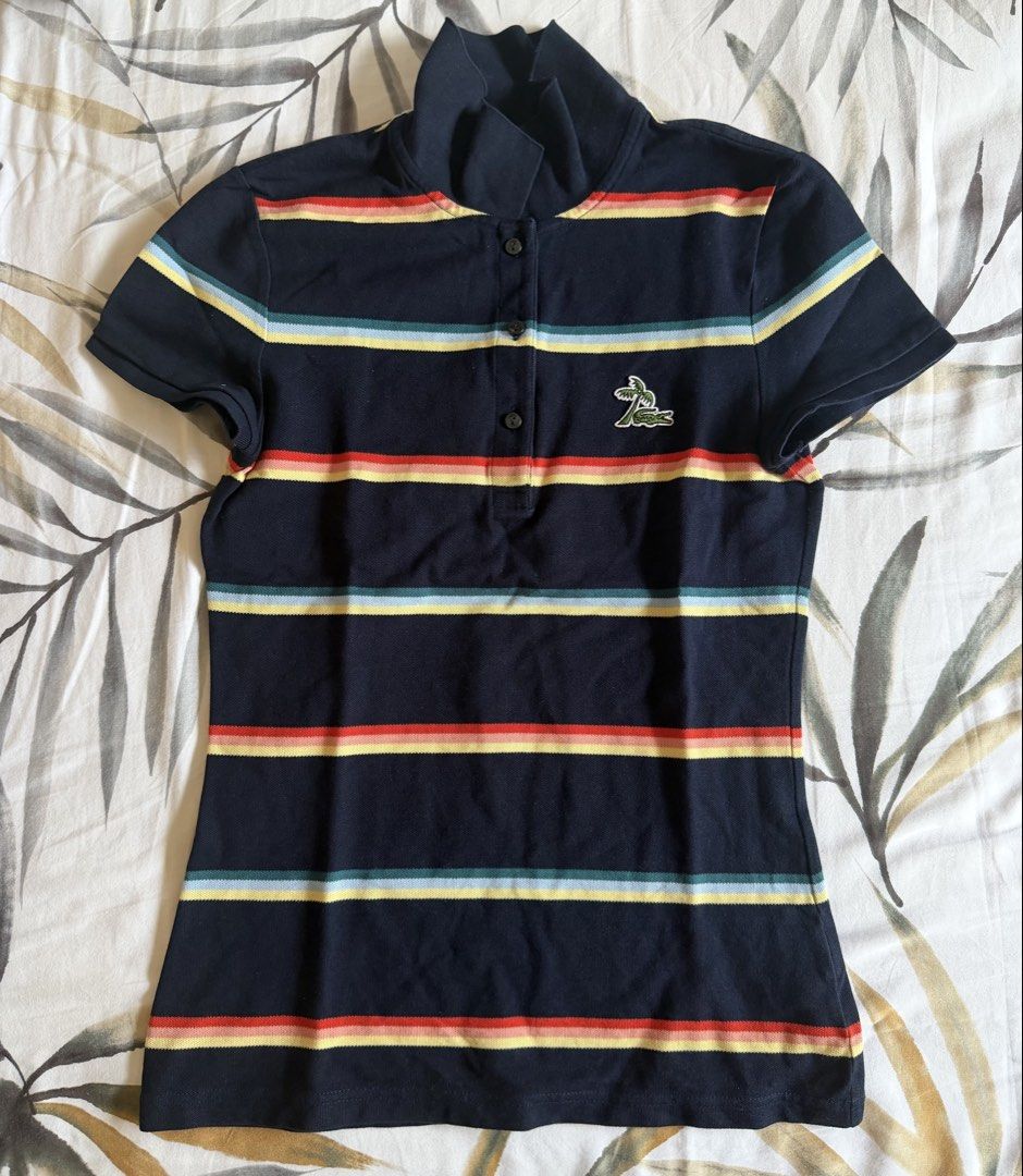 Lacoste Navy Striped Polo Shirt (Category: Tshirts & Polo Shirts ) located in Quezon City. Submitted by tancloset6 (Listing ID 1466412030, Image 1). Description: - Brand: Lacoste - Size: 36 - Color: Navy blue with red, yellow, and turquoise horizontal stripes - Material: Soft and comfortable cotton knit - Design: Short sleeves, 3-button placket, high collar design - Special Detail: Rare embroidered crocodile logo with a palm tree design - Conditi