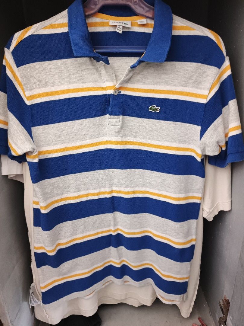 Lacoste polo shirt (Category: Activewear) located in Odiongan. Submitted by thriftngo26 (Listing ID 1466356635, Image 1). Description: This is a blue, gray, and yellow striped short-sleeve polo shirt by Lacoste featuring the brand's signature embroidered green crocodile logo on the chest.