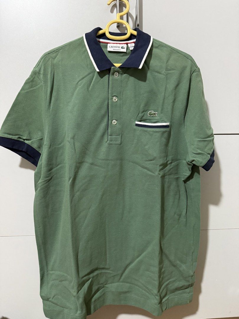 Lacoste Regular Fit Polo Shirt Green (Category: Tshirts & Polo Shirts ) located in Manila. Submitted by mpt99876 (Listing ID 1466520982, Image 2). Description: - Authentic Green Lacoste Polo Shirt - Size: XL - Fit: Regular - Features: Classic crocodile logo on chest - Design: Contrasting navy collar and pocket trim with white stripes - Sleeves: Short with navy trim - Closure: Button-up placket.