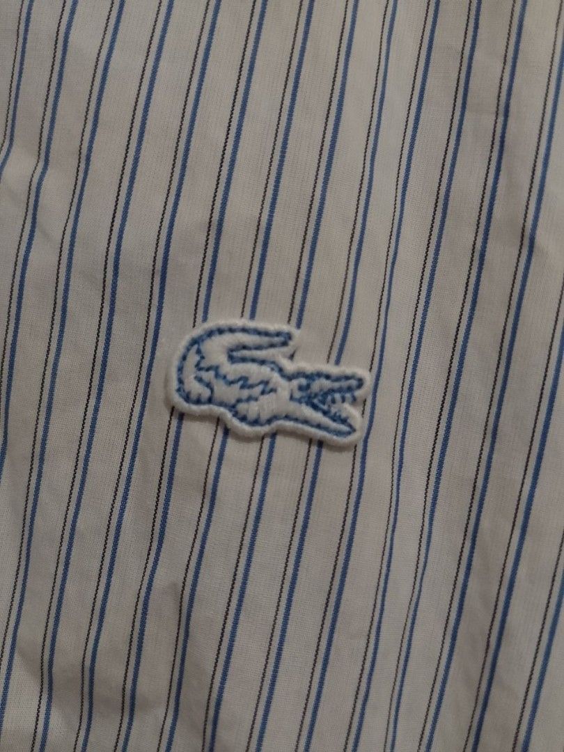Lacoste Regular Fit Striped Long Sleeve Button-Down Shirt (Category: Tshirts & Polo Shirts ) located in Manila. Submitted by rence1010141877 (Listing ID 1466402677, Image 2). Description: - Brand: Lacoste - Design: White with blue and grey vertical stripes - Details: Classic embroidered crocodile on the chest pocket, collar neckline, and long sleeves with button cuffs - Fit: Regular fit, Tagged French size 45 (US XL/2XL) - Style: Versatile; easy 