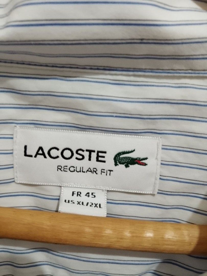 Lacoste Regular Fit Striped Long Sleeve Button-Down Shirt (Category: Tshirts & Polo Shirts ) located in Manila. Submitted by rence1010141877 (Listing ID 1466402677, Image 3). Description: - Brand: Lacoste - Design: White with blue and grey vertical stripes - Details: Classic embroidered crocodile on the chest pocket, collar neckline, and long sleeves with button cuffs - Fit: Regular fit, Tagged French size 45 (US XL/2XL) - Style: Versatile; easy 