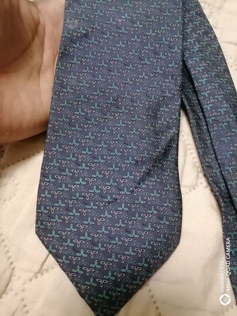 Lancel Paris Blue Patterned Silk Tie (Category: Ties) located in Naga. Submitted by mrwisethrifter (Listing ID 1466369457, Image 1). Description: Lancel Paris tie in dark blue. Pattern features small teal and grey geometric motifs all over. Made in France from 100% silk. Soft fabric with a clean drape. Brand tag stitched on the back loop. Standard width, ready to wear for work or formal events..