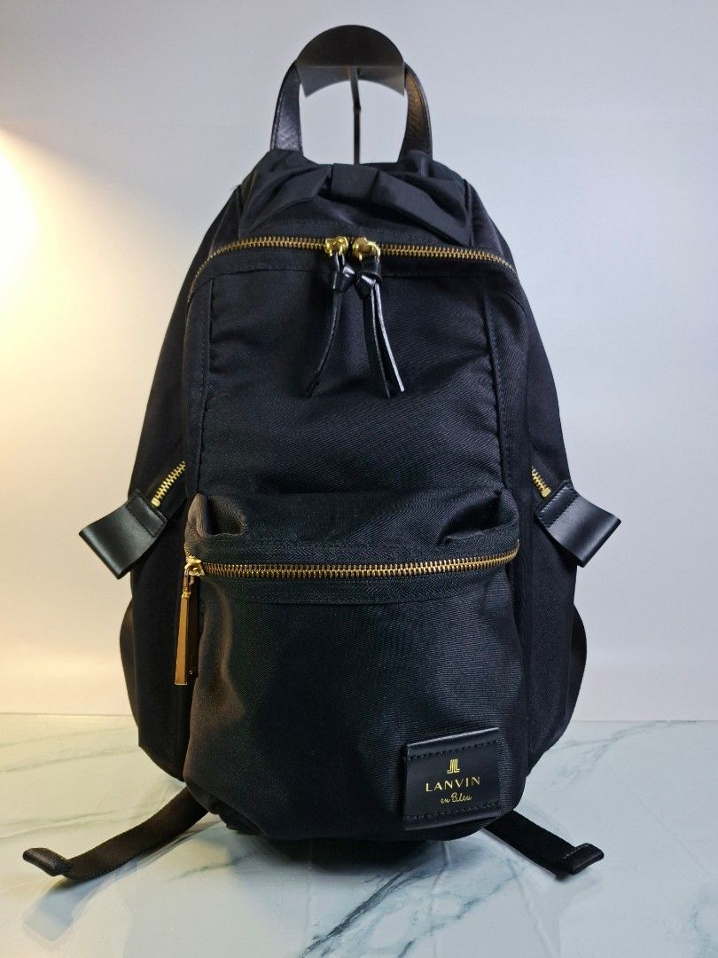Lanvin en Bleu Black Nylon Backpack with Bow Detail (Category: Luxury Bags & Wallets) located in Pasay City. Submitted by onick_79 (Listing ID 1466493671, Image 1). Description: - Brand: Lanvin en Bleu - Material: Durable black nylon with gold hardware - Design: Features a cute ribbon detail near the top handle - Storage: Dual front zippered compartments and convenient side zipper access - Comfort: Adjustable shoulder straps with padded support -