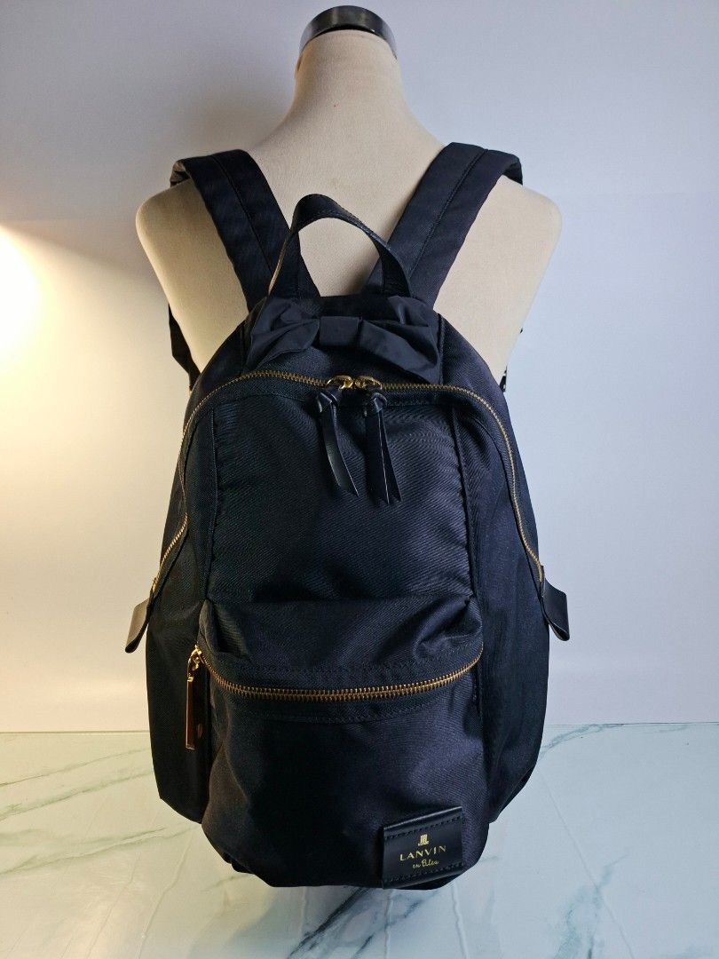Lanvin en Bleu Black Nylon Backpack with Bow Detail (Category: Luxury Bags & Wallets) located in Pasay City. Submitted by onick_79 (Listing ID 1466493671, Image 2). Description: - Brand: Lanvin en Bleu - Material: Durable black nylon with gold hardware - Design: Features a cute ribbon detail near the top handle - Storage: Dual front zippered compartments and convenient side zipper access - Comfort: Adjustable shoulder straps with padded support -