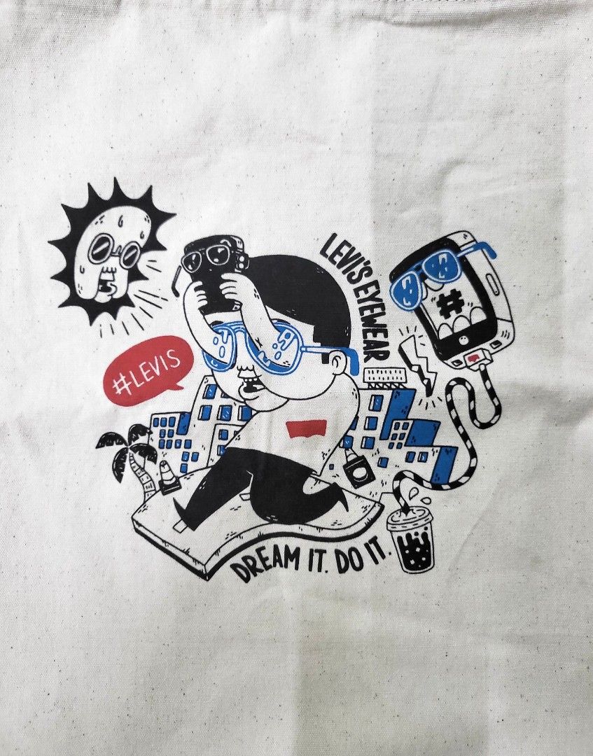 Levi's Eyewear Graphic Canvas Tote Bag (Category: Tote Bags) located in Manila. Submitted by marson_lagman (Listing ID 1466436136, Image 3). Description: - Brand: Levi's Eyewear - Color: Off-white canvas with red and blue shoulder handles - Design: Quirky comic-style print with 'Dream it. Do it.' text - Condition: Brand new, still sealed in original plastic packaging - Perfect for daily use, school, or casual outings.