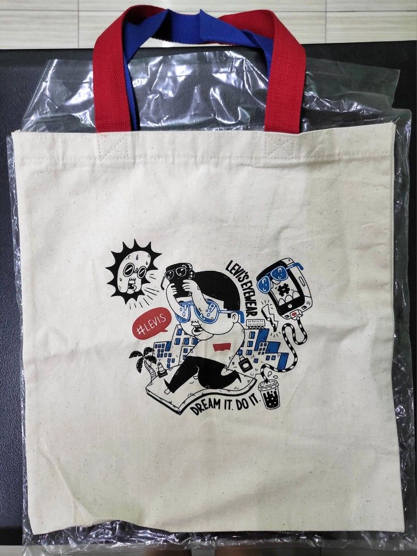 Levi's Eyewear Graphic Canvas Tote Bag (Category: Tote Bags) located in Manila. Submitted by marson_lagman (Listing ID 1466436136, Image 1). Description: - Brand: Levi's Eyewear - Color: Off-white canvas with red and blue shoulder handles - Design: Quirky comic-style print with 'Dream it. Do it.' text - Condition: Brand new, still sealed in original plastic packaging - Perfect for daily use, school, or casual outings.