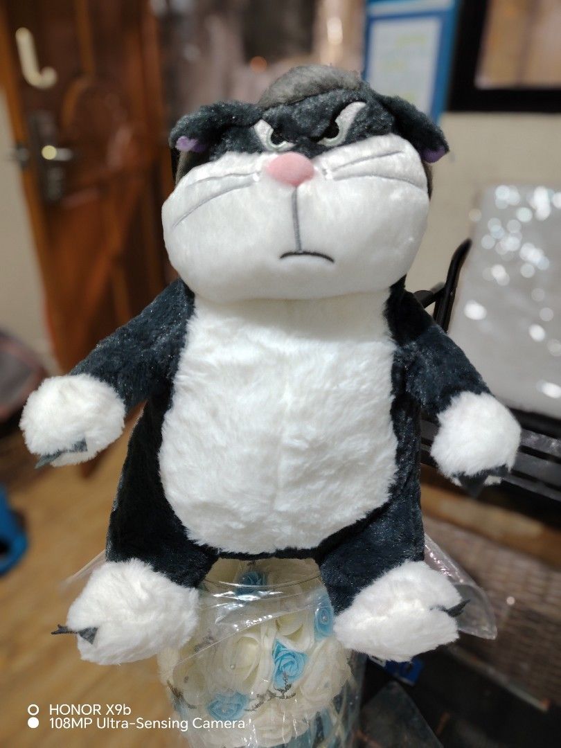 Licifer from Cinderella Grumpy Cat Plush Toy (Category: Plushies & Soft Toys) located in Manila. Submitted by justybelieve2026 (Listing ID 1466561324, Image 2). Description: - Type: Medium plush stuffed animal - Design: Black and white cat with an angry expression, pink nose, and embroidered mouth - Details: Soft furry body, white belly, and white paws with stitched claws - Clean and well-maintained - Best for: Cuddling or room decor - With zippe