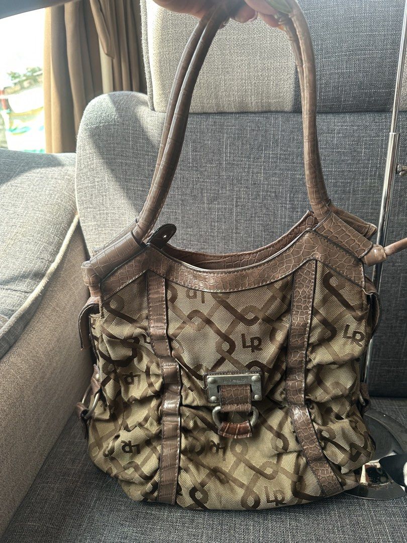 Linea K Brown Monogram Shoulder Handbag (Category: Shoulder Bags) located in Manila. Submitted by goldenhorse-dafc (Listing ID 1466410787, Image 2). Description: - Stylish brown patterned shoulder bag with croc-embossed faux leather trim - Features a chic metal buckle accent on the front - Comfortable double straps designed for easy shoulder wear - Secure main zipped compartment with extra slip pockets for phone and keys - Clean, intact inner lin