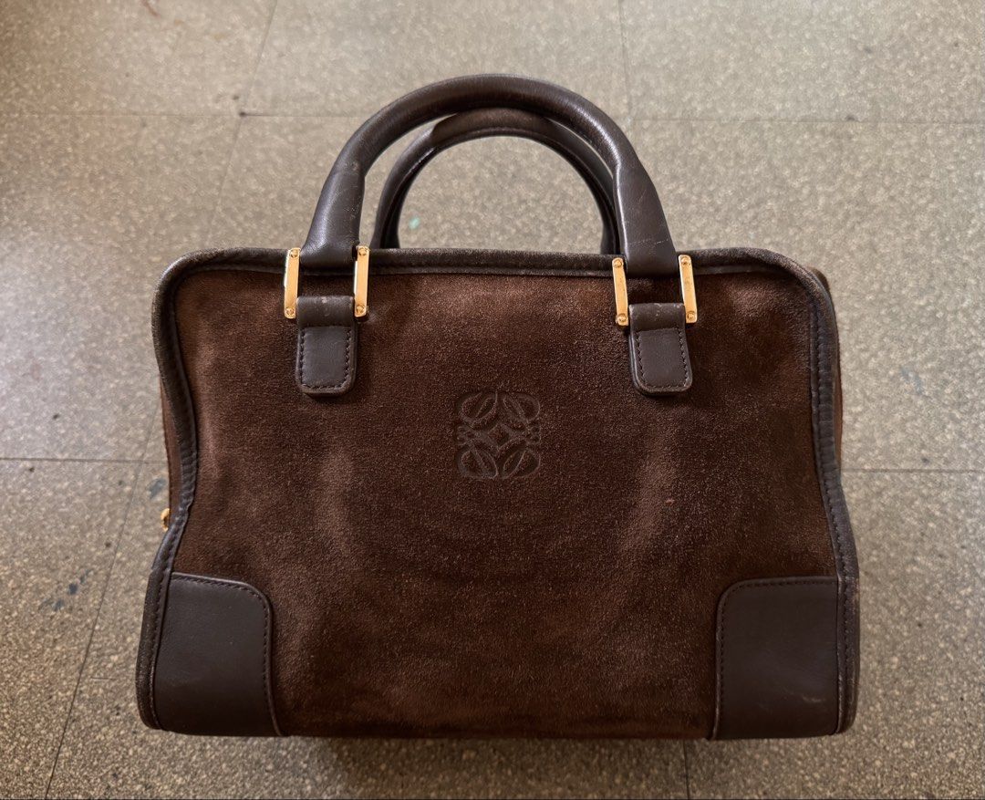 Loewe Brown Suede Amazona Handbag (Category: Luxury Bags & Wallets) located in Cavite. Submitted by aldrindela40142 (Listing ID 1466538642, Image 1). Description: Authentic Vintage brown suede Loewe handbag with dark brown leather trim and gold hardware. Classic embossed Anagram logo centered on the front. Dual rolled leather handles showing some wear from use. Zipper closure with engraved Loewe metal pull on the side. Structured boxy shape with 