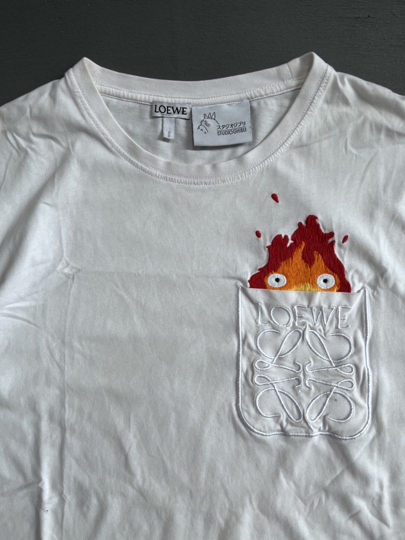 LOEWE X STUDIO GHIBLI 🔥 (Category: Tshirts & Polo Shirts ) located in Bacolod City. Submitted by johnkiercabungcal09 (Listing ID 1466391702, Image 2). Description: LOEWE x Studio Ghibli 🔥 Calcifer Peek-a-Boo Tee Size: S on tag (fits M) Dimes: 19.5” Width x 26” Length Condition: 9.5/10 - Excellent, no cracks / fade Detail: Full embroidery Calcifer, embroidered Anagram pocket Tags: Complete (Loewe + Ghibli Totoro tag + wash tag) Made in Portugal 
