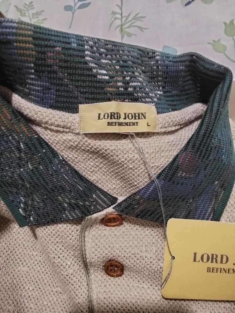 Lord John Refinement Polo Shirt Beige Size L (Category: Tshirts & Polo Shirts ) located in Davao. Submitted by honeymeee (Listing ID 1466444292, Image 3). Description: - Brand: Lord John Refinement - Color: Beige with green contrast pattern on collar and pocket trim - Size: Large - Details: Wooden buttons, ribbed bottom hem - Condition: Brand new with original tags attached - Packaging: Includes original Jacques Esterel branded box.