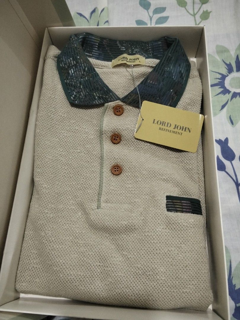Lord John Refinement Polo Shirt Beige Size L (Category: Tshirts & Polo Shirts ) located in Davao. Submitted by honeymeee (Listing ID 1466444292, Image 2). Description: - Brand: Lord John Refinement - Color: Beige with green contrast pattern on collar and pocket trim - Size: Large - Details: Wooden buttons, ribbed bottom hem - Condition: Brand new with original tags attached - Packaging: Includes original Jacques Esterel branded box.
