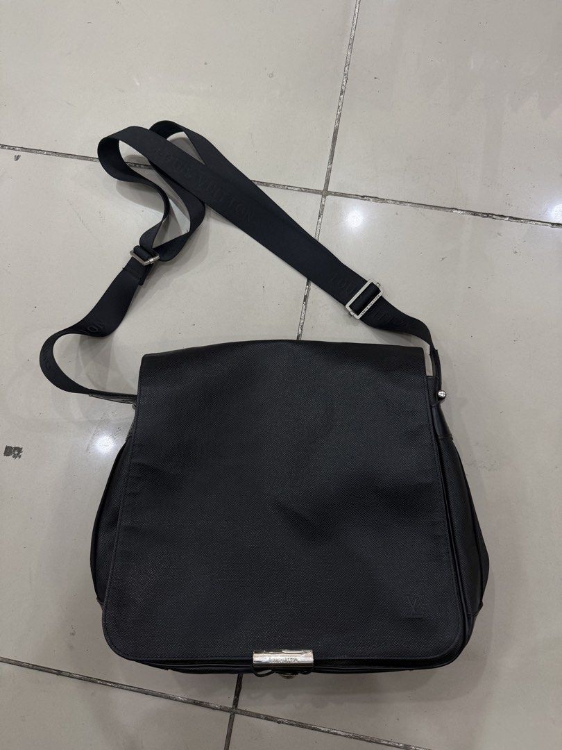 Louis Vuitton Black Messenger Bag (Category: Luxury Bags & Wallets) located in Bacolod City. Submitted by kitcarsonduff (Listing ID 1466476974, Image 1). Description: - Authentic black textured leather messenger bag - Adjustable fabric shoulder strap with Louis Vuitton lettering - Silver-tone metal hardware with secure front buckle closure - Convenient exterior back zip pocket for easy access - Subtle debossed LV initials on the lower corner and 
