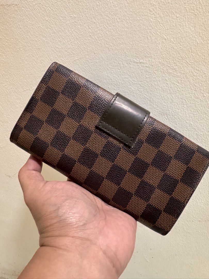 Louis Vuitton Damier Ebene Long Wallet (Category: Luxury Bags & Wallets) located in Cavite. Submitted by aldrindela40142 (Listing ID 1466537288, Image 3). Description: - Brand: Louis Vuitton - Style: Long Wallet / Clutch - Material: Damier Ebene Canvas - Hardware: Gold-tone with engraved logo - Closure: Front snap tab - Interior: Zippered coin pocket with LV pull, multiple card slots, and spacious compartments - Condition: Excellent pre-loved con