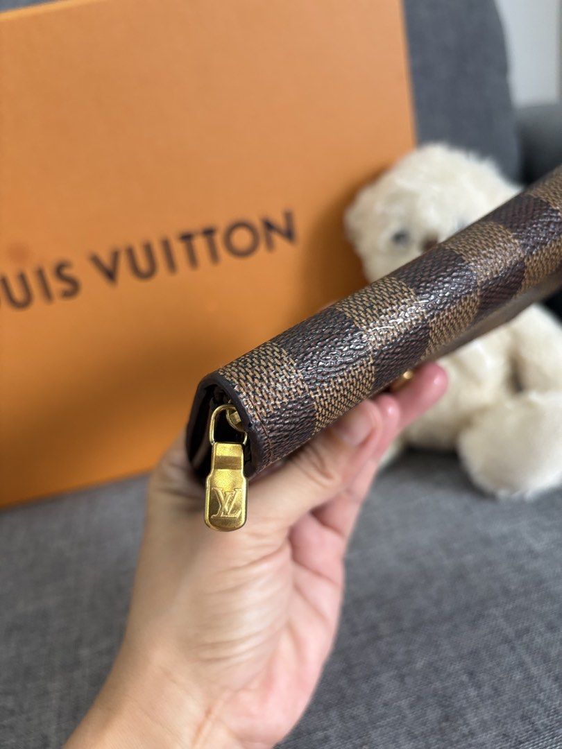 Louis Vuitton Damier Ebene Wallet (Category: Luxury Bags & Wallets) located in Alicia. Submitted by berly06 (Listing ID 1466397027, Image 3). Description: - Authentic Louis Vuitton wallet in classic Damier Ebene canvas - Features iconic brown checkered pattern with polished gold hardware - Secure snap closure for everyday convenience - Interior stamped Louis Vuitton Paris, made in Spain - Comes with the original orange box.