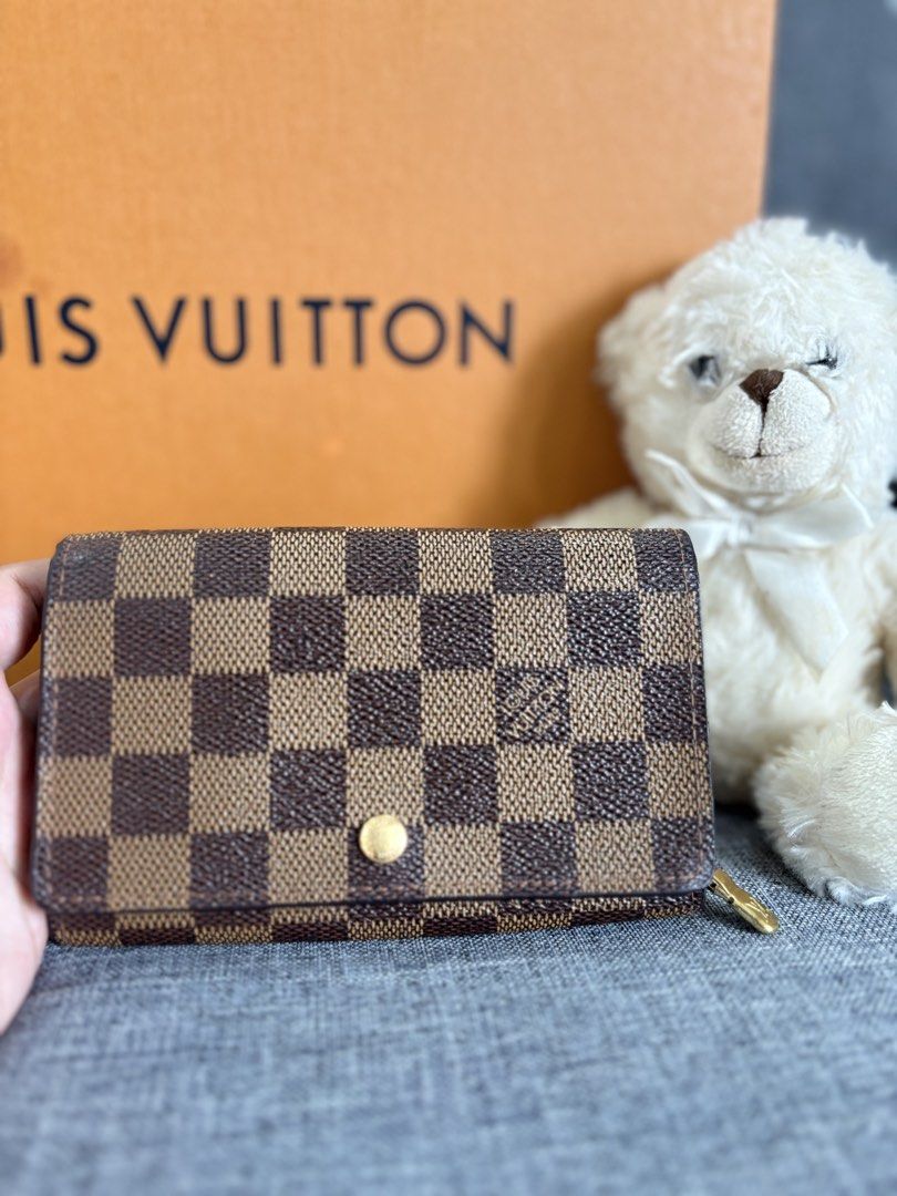 Louis Vuitton Damier Ebene Wallet (Category: Luxury Bags & Wallets) located in Alicia. Submitted by berly06 (Listing ID 1466397027, Image 2). Description: - Authentic Louis Vuitton wallet in classic Damier Ebene canvas - Features iconic brown checkered pattern with polished gold hardware - Secure snap closure for everyday convenience - Interior stamped Louis Vuitton Paris, made in Spain - Comes with the original orange box.