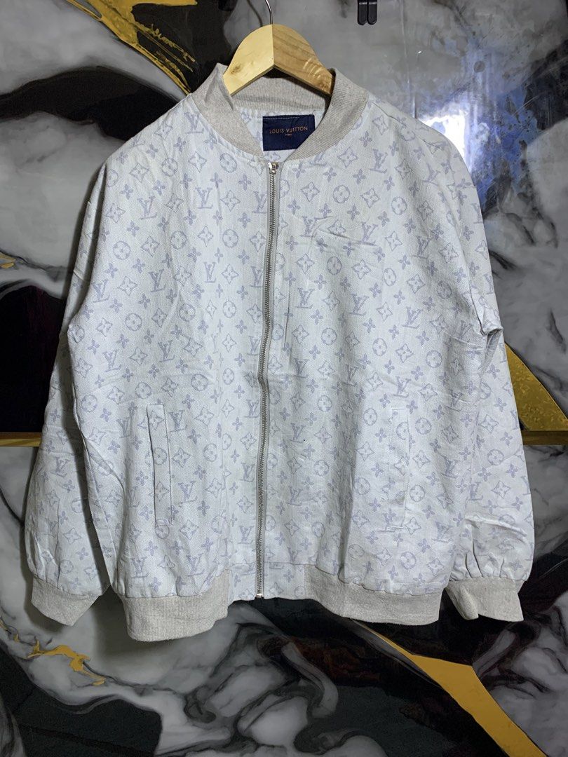 Louis Vuitton Monogram Denim Bomber Jacket (Category: Coats, Jackets and Outerwear) located in Davao. Submitted by youngboythrift25 (Listing ID 1466405961, Image 1). Description: Louis Vuitton zip-up bomber jacket. Light grey denim fabric covered all over in the classic LV monogram print. Ribbed knit collar, cuffs, and hem. Metal zipper closure down the front. Slip pockets on each side. Black leather brand patch with silver hardware on the back u