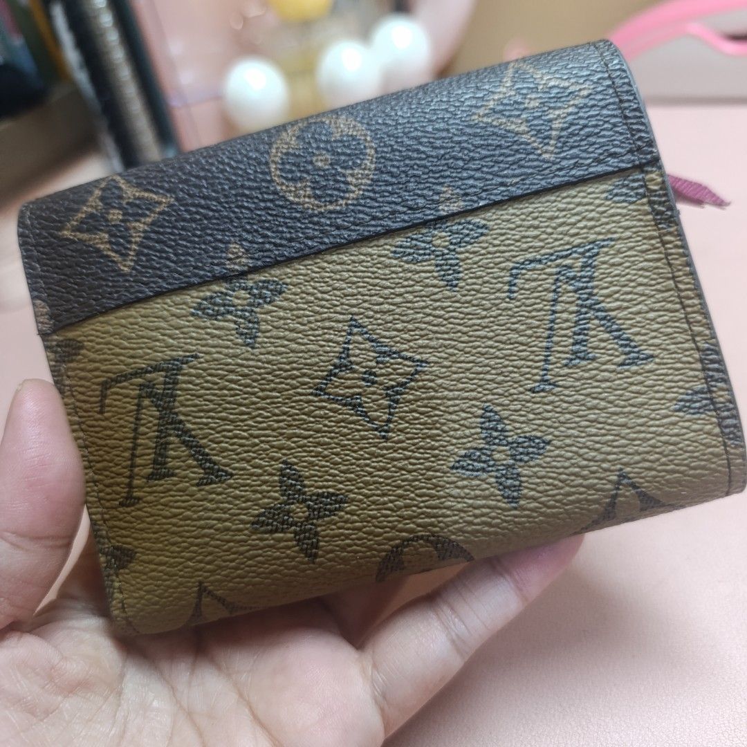 Louis Vuitton Monogram Tri-Fold Wallet (Category: Luxury Bags & Wallets) located in Las Pinas. Submitted by min_yanna (Listing ID 1466483744, Image 2). Description: Given to me a sa gift. CANNOT GUARANTEE AUTHENTICITY. Louis Vuitton tri-fold wallet in brown monogram canvas with a contrasting dark flap. Snap closure button shows minor wear. Inside has a rich purple-pink lining, multiple card slots, and a zipped coin compartment on the side. Made i