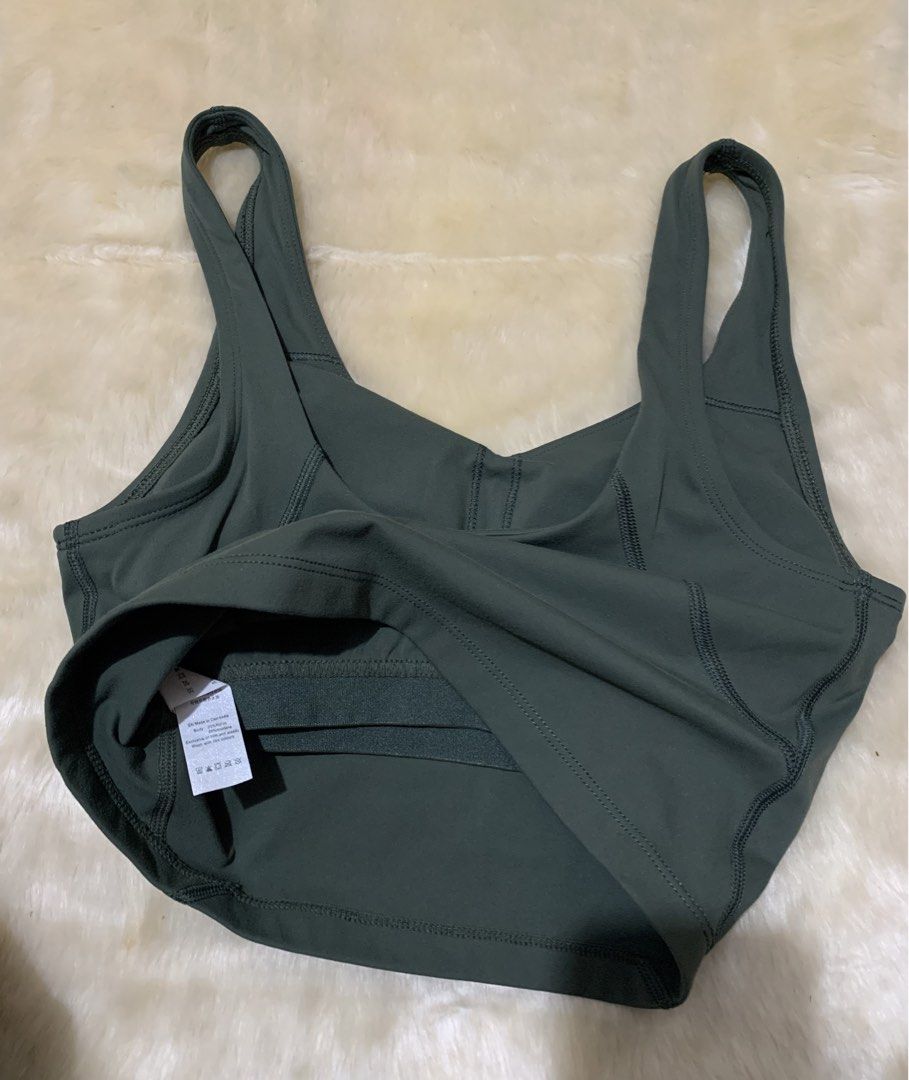 Lululemon Dark Green Align Tank Top (Category: Sleeveless) located in Bayombong. Submitted by birkensaddiction (Listing ID 1466339195, Image 3). Description: - Brand: Lululemon - Color: Dark green - Style: V-neck with trendy multi-strap cutout back - Support: Built-in shelf bra included - Details: Signature white omega logo at the back neckline - Condition: Tag intact, soft and stretchy fabric - Ideal for: Gym, yoga, or everyday activewear -S on 