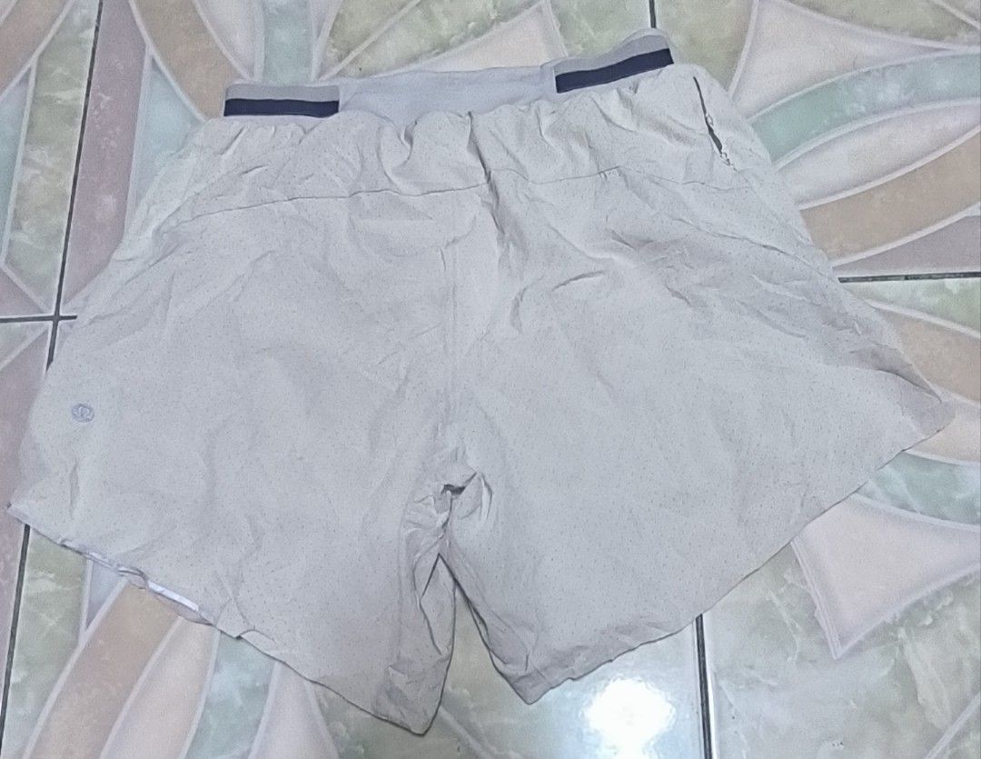 Lululemon Men's Athletic Shorts Size S (Category: Shorts) located in Manila. Submitted by itsmelawrence (Listing ID 1466357546, Image 1). Description: - Brand: Lululemon - Item: Men's Athletic Shorts - Size: S 26+ x 13 - Color: Light Grey - Material: Perforated fabric for maximum breathability - Features: Elastic waistband with adjustable drawstring, iconic silver reflective logo on lower hem - Condition: Excellent, great for running or gym sessi