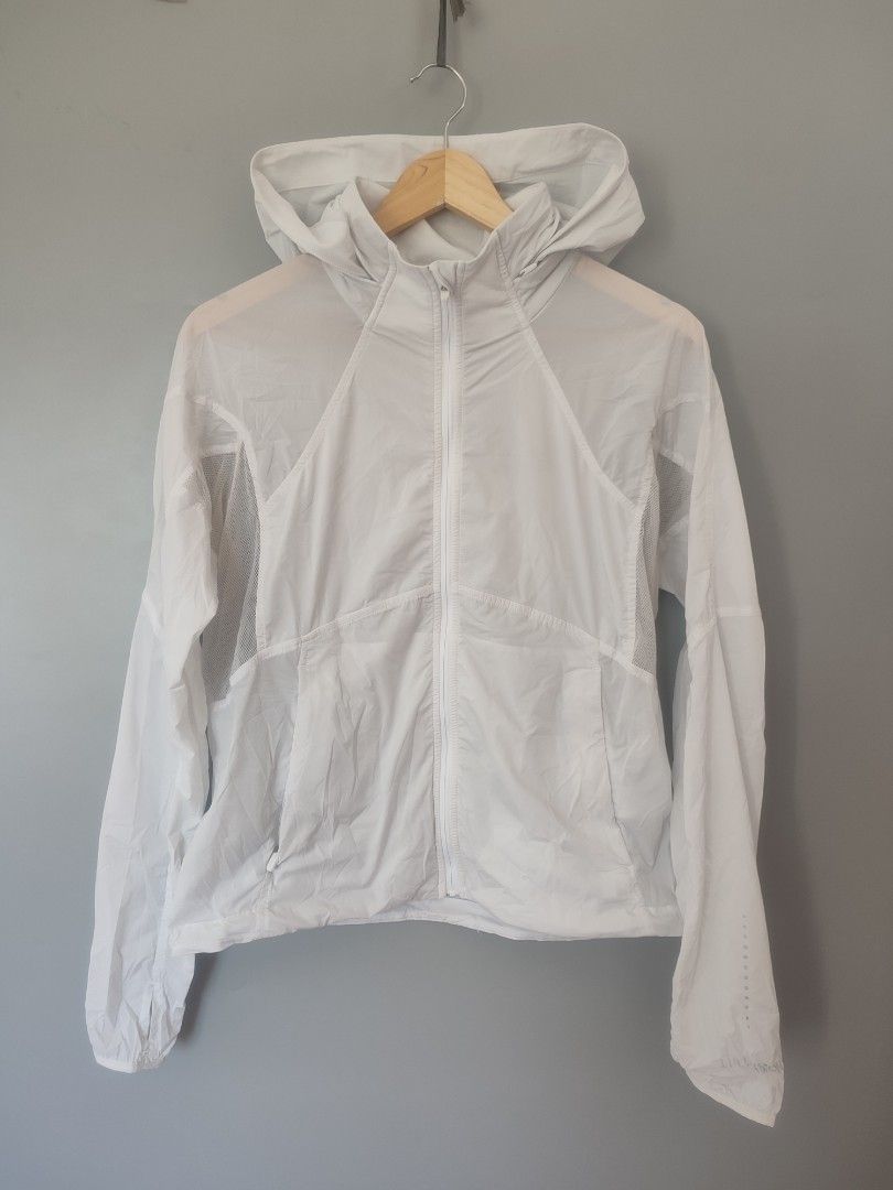 Lululemon White Lightweight Hooded Running Jacket (Category: Coats, Jackets and Outerwear) located in Lipa City. Submitted by gudoys_outdoor16 (Listing ID 1466461914, Image 1). Description: Lululemon lightweight running jacket in bright white. Full zip front with matching hood, drawstring hem, and breathable mesh panels on the back and underarms. Reflective dots on the sleeve and classic silver omega logo near the lower back hem. Two front zipper