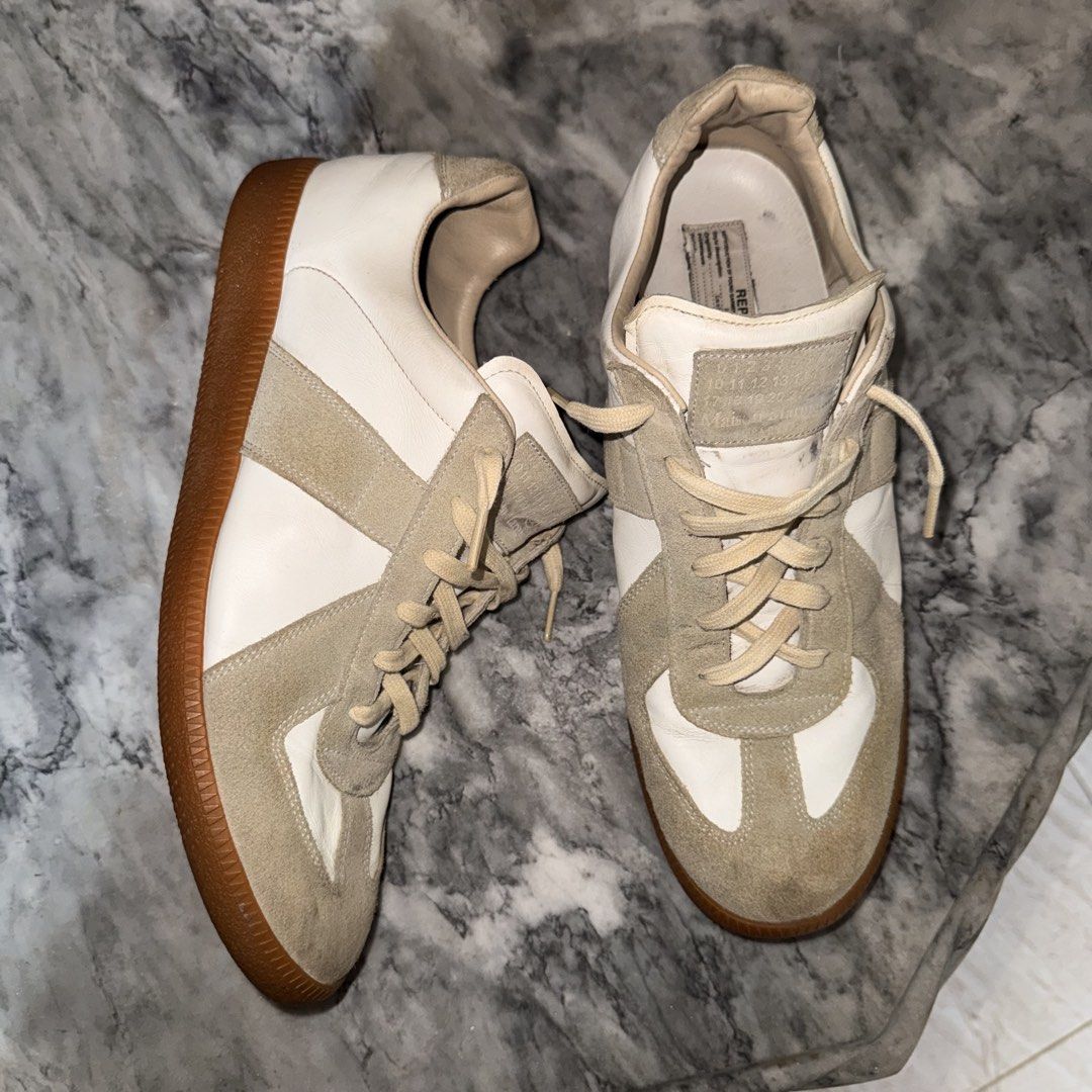 Maison Margiela Replica Sneakers Size 44 (Category: Casual Shoes) located in Daraga. Submitted by sudeboy031092 (Listing ID 1466506048, Image 1). Description: - Brand/Model: Maison Margiela Replica GAT Sneakers - Colorway: White leather with grey suede overlays and classic gum sole - Size: EU 44 (Made in Italy) - Authentic Details: Size stamp on inner tongue and iconic numbered text patch with intentional tearing on the footbed - Condition: Norma