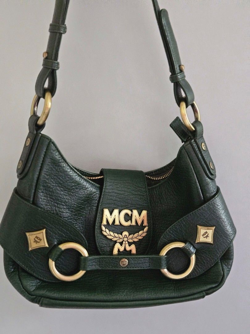 MCM Dark Green Leather Shoulder Bag (Category: Luxury Bags & Wallets) located in Manila. Submitted by missyyyxx (Listing ID 1466452552, Image 1). Description: - Brand: MCM (RARE, HARD TO FIND! 😍) - Material: Premium dark green pebbled leather - Hardware: Gold-tone with signature front logo plate - Closure: Top zipper closure - Interior: Fabric-lined with a convenient inner zip pocket - Strap: Adjustable strap with brass rings and studs - Conditi