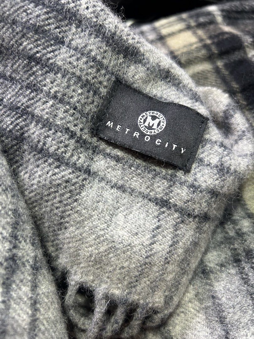 METROCITY Grey Plaid Winter Scarf (Category: Scarves) located in Manila. Submitted by starbalesukandjapansurplus (Listing ID 1466463281, Image 2). Description: - Brand: Metrocity - Design: Classic grey, black, and white tartan plaid - Material: Soft textured wool-blend for cozy warmth - Details: Chic fringe ends along the bottom hem - Styling: Standard length, versatile neutral colors that match any coat or jacket.