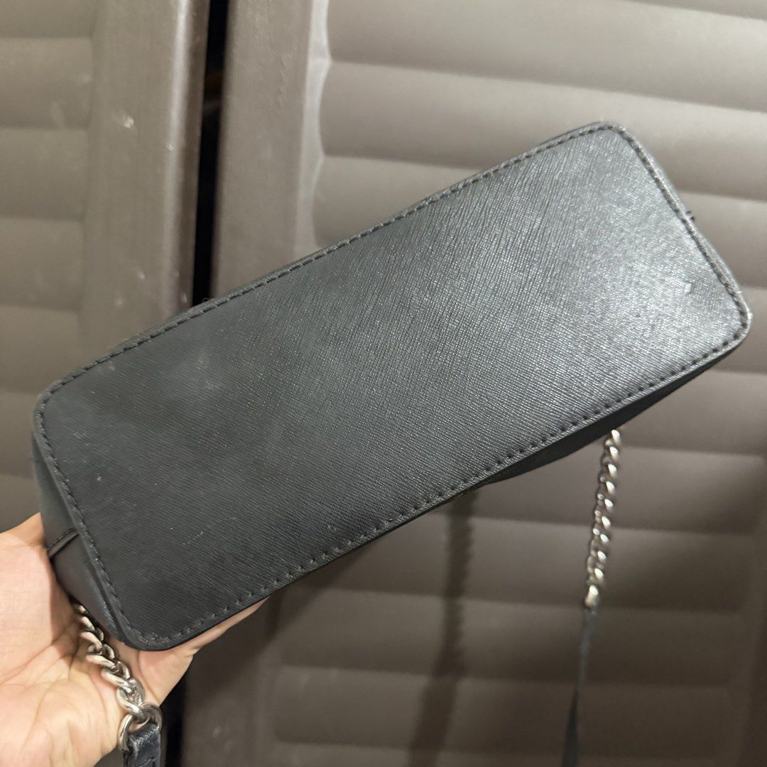 Michael Kors Black Dome Crossbody Bag (Category: Cross-body Bags) located in Rizal. Submitted by lovegclothingph (Listing ID 1466476302, Image 3). Description: - Brand: Michael Kors - Material: Premium black Saffiano leather - Hardware: Silver-tone with chain-link strap detail - Exterior: Front slip pocket with metal logo lettering - Closure: Secure zip-top closure - Structure: Flat bottom design (stands upright) - Size: Compact, ideal for going 