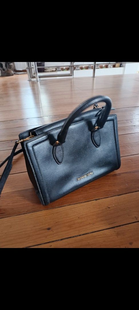 Michael Kors Black Leather Satchel Handbag (Category: Luxury Bags & Wallets) located in Baguio. Submitted by daniel_c27 (Listing ID 1466529677, Image 1). Description: - Brand: Michael Kors - Material: Premium black pebble leather - Hardware: Elegant gold-tone with metal lettering logo - Closure: Secure top zipper closure - Straps: Dual top handles and a detachable/adjustable shoulder strap - Extras: Iconic hanging circular MK logo charm - Conditi