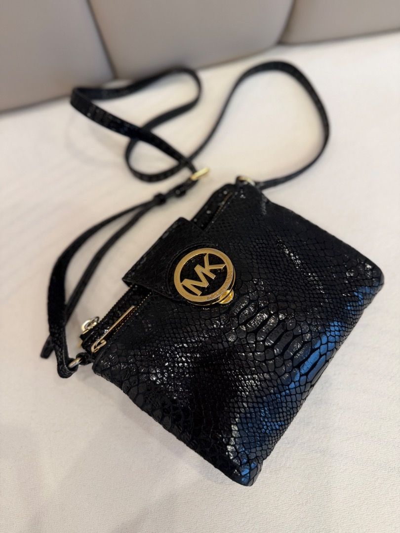 Michael Kors Black Snakeskin Pattern Crossbody Bag (Category: Cross-body Bags) located in Rizal. Submitted by je_resada (Listing ID 1466345363, Image 2). Description: - Brand: Michael Kors - Color: Classic Black with textured snakeskin finish - Hardware: Elegant gold-tone accents and zipper closures - Details: Features signature round MK logo medallion and front flap - Strap: Adjustable thin strap for comfortable wear - Size: Compact and convenie