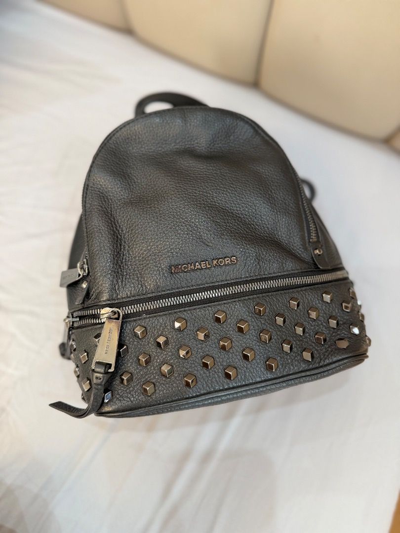 Michael Kors Black Studded Leather Backpack (Category: Backpacks) located in Rizal. Submitted by je_resada (Listing ID 1466345116, Image 2). Description: - Black pebbled leather backpack - Chic silver-tone metal studs along the bottom - Front zip pocket and sturdy top handle - Interior lined with convenient slip pockets - Compact size, perfect for everyday carry - 100% working smooth zipper closures.