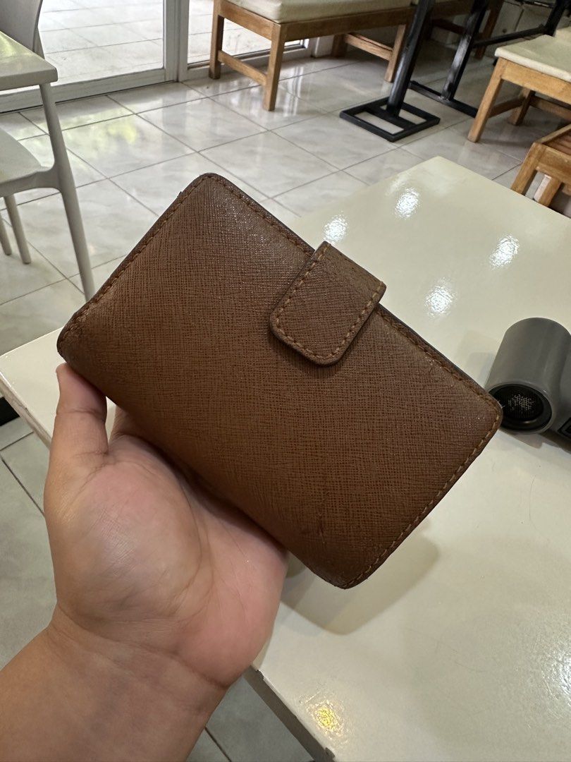 Michael Kors Brown Saffiano Leather Wallet (Category: Wallets & Card holders) located in Cauayan City . Submitted by sherinejoy_ (Listing ID 1466403497, Image 2). Description: - Authentic Michael Kors wallet - Material: Premium brown Saffiano leather - Closure: Secure snap button - Interior: Multiple card slots with signature MK logo lining - Size: Compact design fits easily into any handbag - Color: Classic tan brown that matches any outfit.