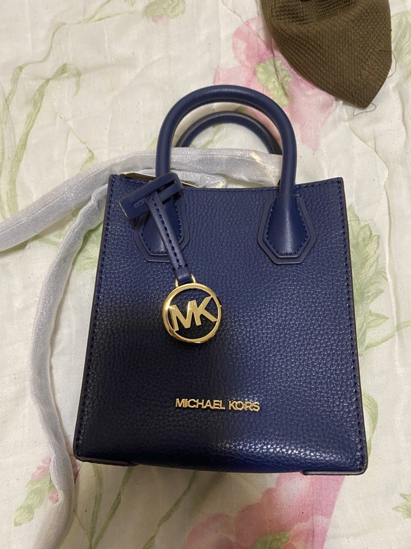 Michael Kors Navy Blue Mini Tote Bag (Category: Tote Bags) located in Pasig City. Submitted by raine.lb (Listing ID 1466408153, Image 1). Description: - Brand: Michael Kors - Color: Navy Blue - Material: Pebble leather texture - Hardware: Gold-tone with hanging MK circle charm pendant - Handles: Dual top handles + adjustable shoulder strap included - Interior: Clean and spacious enough for daily essentials - Condition: Brand new with protective f