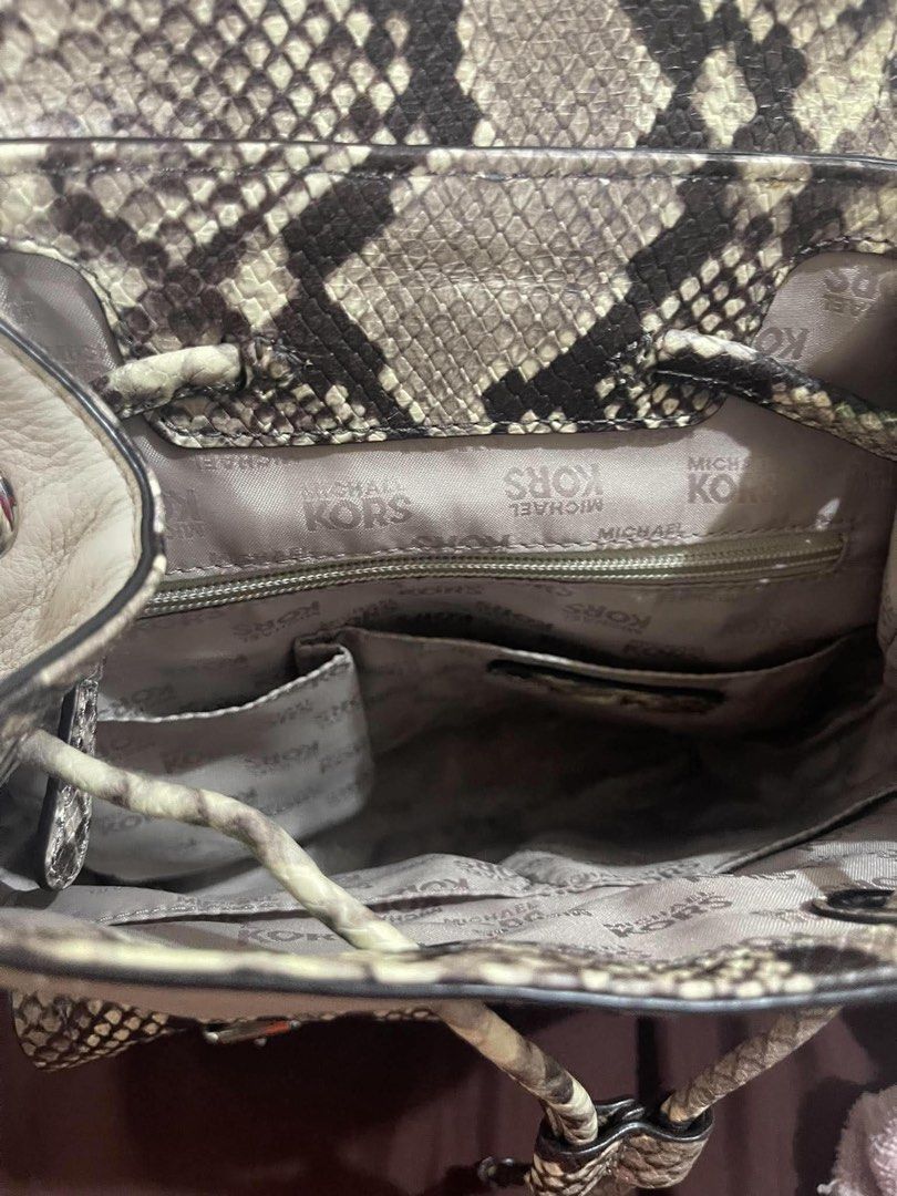 Michael Kors Python Print Leather Backpack (Category: Backpacks) located in Quezon City. Submitted by pickleballpaddle (Listing ID 1466440953, Image 3). Description: - Brand: Michael Kors - Material: Cream pebble leather with faux snakeskin print - Color: Cream and grey tones - Closure: Flap top with secure buckle detail - Exterior: Handy front pockets and sturdy top handle - Straps: Adjustable back straps for comfort - Interior: Signature Michae