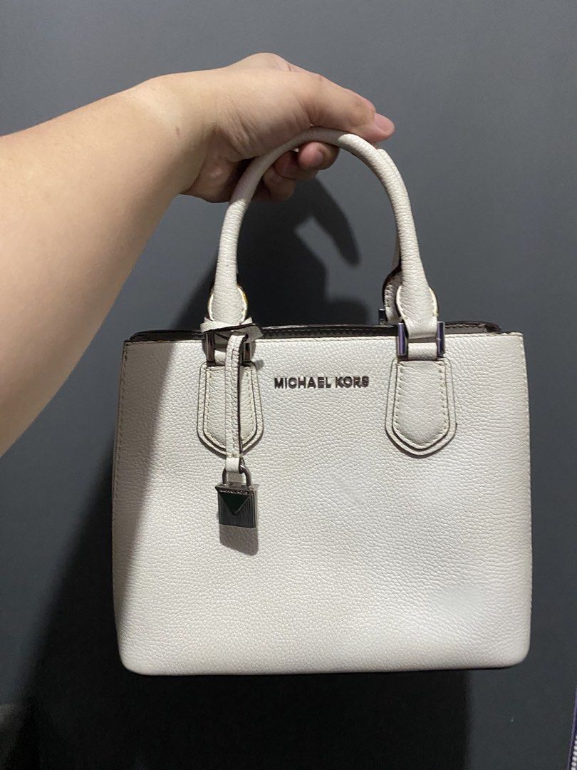 Michael Kors White Leather Satchel Handbag (Category: Cross-body Bags) located in Batangas. Submitted by bagstolove3.0 (Listing ID 1466470397, Image 1). Description: - Brand: Michael Kors - Material: White pebbled leather with silver-tone hardware - Design: Structured square silhouette with contrast dark brown edge glazing and hanging padlock charm - Carry: Double top handles - Size: Compact, perfect daily grab-and-go bag - Condition: Handles sho
