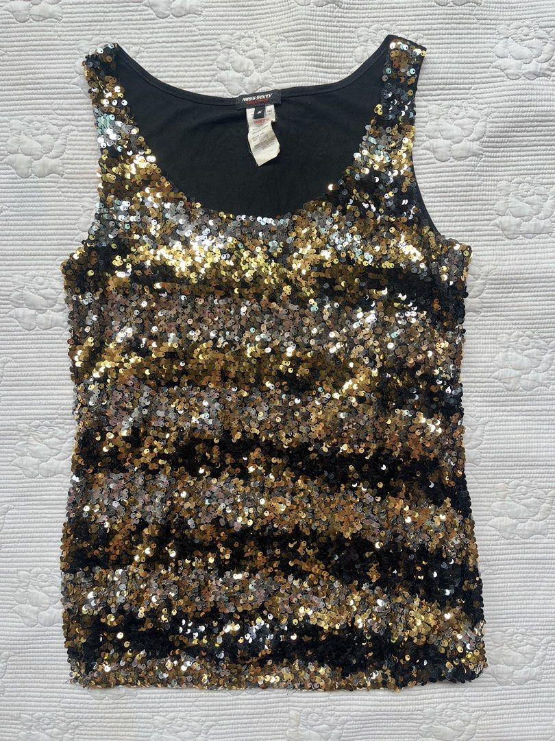 Miss Sixty Black Gold Sequin Tank Top (Category: Sleeveless) located in Alabel. Submitted by geragarhea13830 (Listing ID 1466406746, Image 1). Description: - Brand: Miss Sixty - Design: Sleeveless tank top with scoop neckline - Details: Fully covered in gold, silver, and black sequins with a black fabric backing - Condition: Great statement piece, tag attached at the collar - Occasion: Perfect for parties, clubs, and nights out.