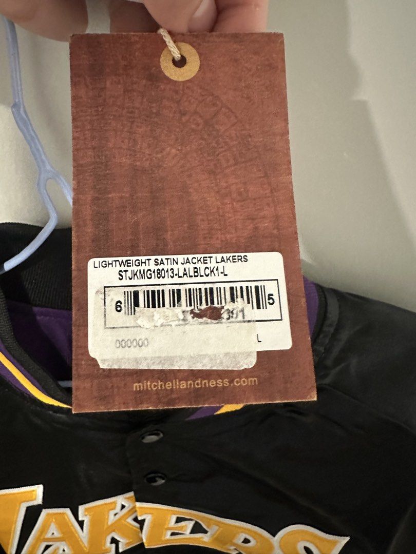 Mitchell & Ness Lakers Satin Jacket (Category: Coats, Jackets and Outerwear) located in Legazpi City. Submitted by jodyeflacko (Listing ID 1466347523, Image 3). Description: - Brand: Mitchell & Ness - Team: Los Angeles Lakers - Material/Style: Lightweight satin jacket in black - Condition: Brand new with original store hangtag attached - Size: Large - SRP is PHP 8,250.