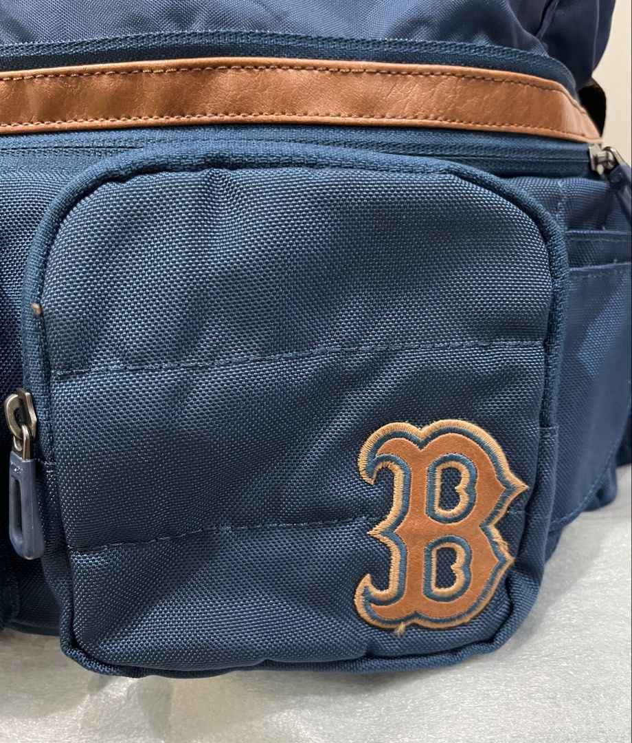 MLB Boston Red Sox Blue Backpack (Category: Backpacks) located in Talisay. Submitted by cherylu (Listing ID 1466504317, Image 2). Description: - Color: Navy blue with brown straps and faux leather trim - Team: Official Boston Red Sox 'B' embroidered patch - Storage: Multiple zippered compartments and pockets for easy organization - Comfort: Adjustable brown shoulder straps with secure plastic buckle closure - Details: Custom MLB-branded zipper pu