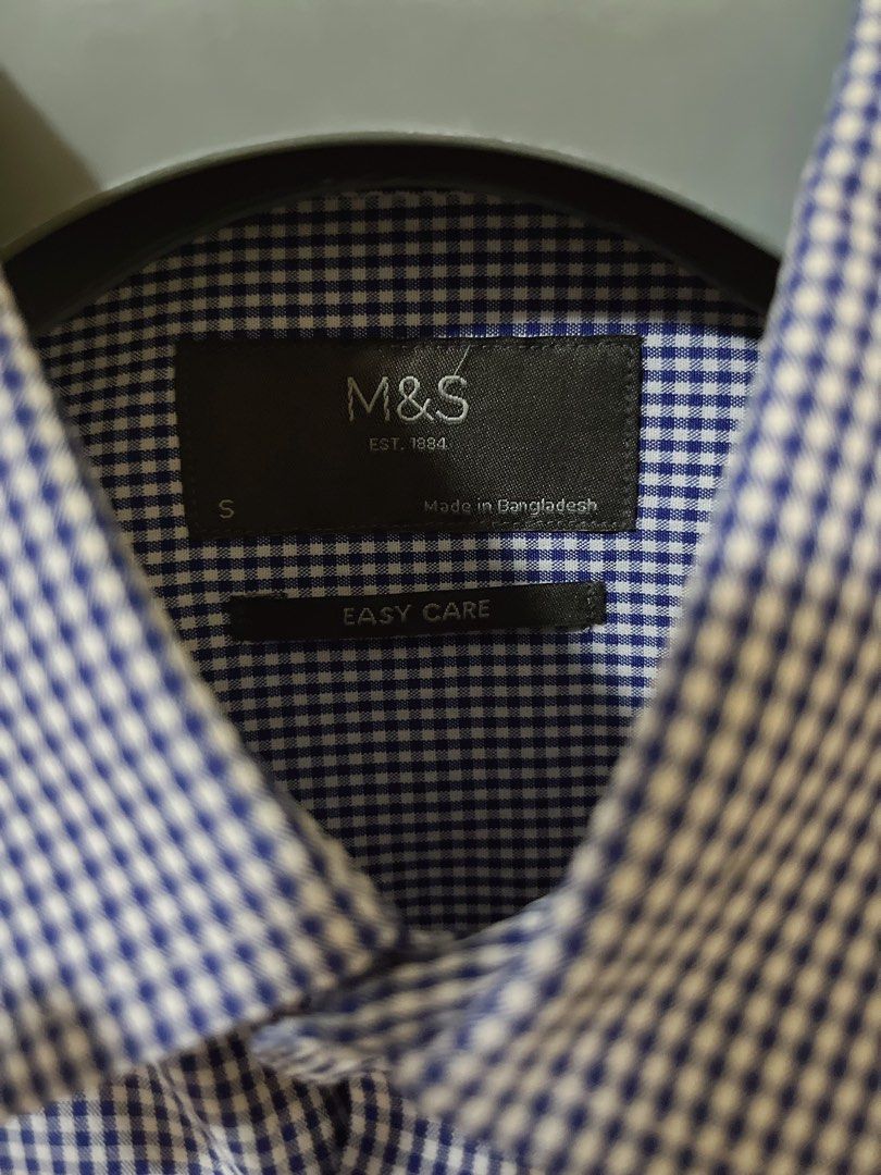 M&S Blue Gingham Short Sleeve Shirt Size S (Category: Tshirts & Polo Shirts ) located in Manila. Submitted by _preciousfinds.2 (Listing ID 1466516650, Image 2). Description: - Brand: Marks & Spencer (M&S) - Design: Blue and white gingham check pattern - Size: S - Features: Short sleeves, classic button-down front, single chest pocket - Material: Easy-care fabric.