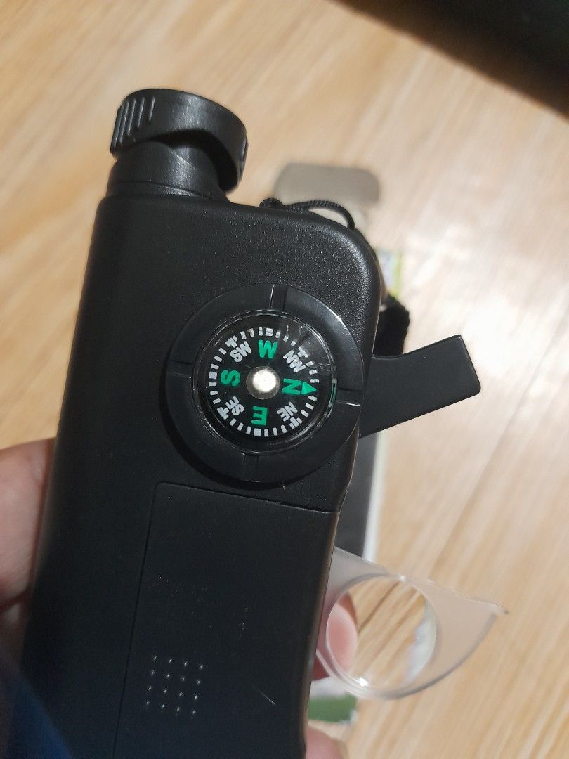 Multifunctional 7-in-1 Outdoor Scope with Compass and LED Light (Category: Hiking & Camping) located in Bocaue. Submitted by marajapansurplus (Listing ID 1466478992, Image 3). Description: - Multi-tool outdoor gadget for hiking, camping, and adventures - Functions include: digital clock, working compass, flashlight, extendable monocular scope, magnifying glass, and whistle - Compact black plastic body equipped with a convenient hand strap - Comes