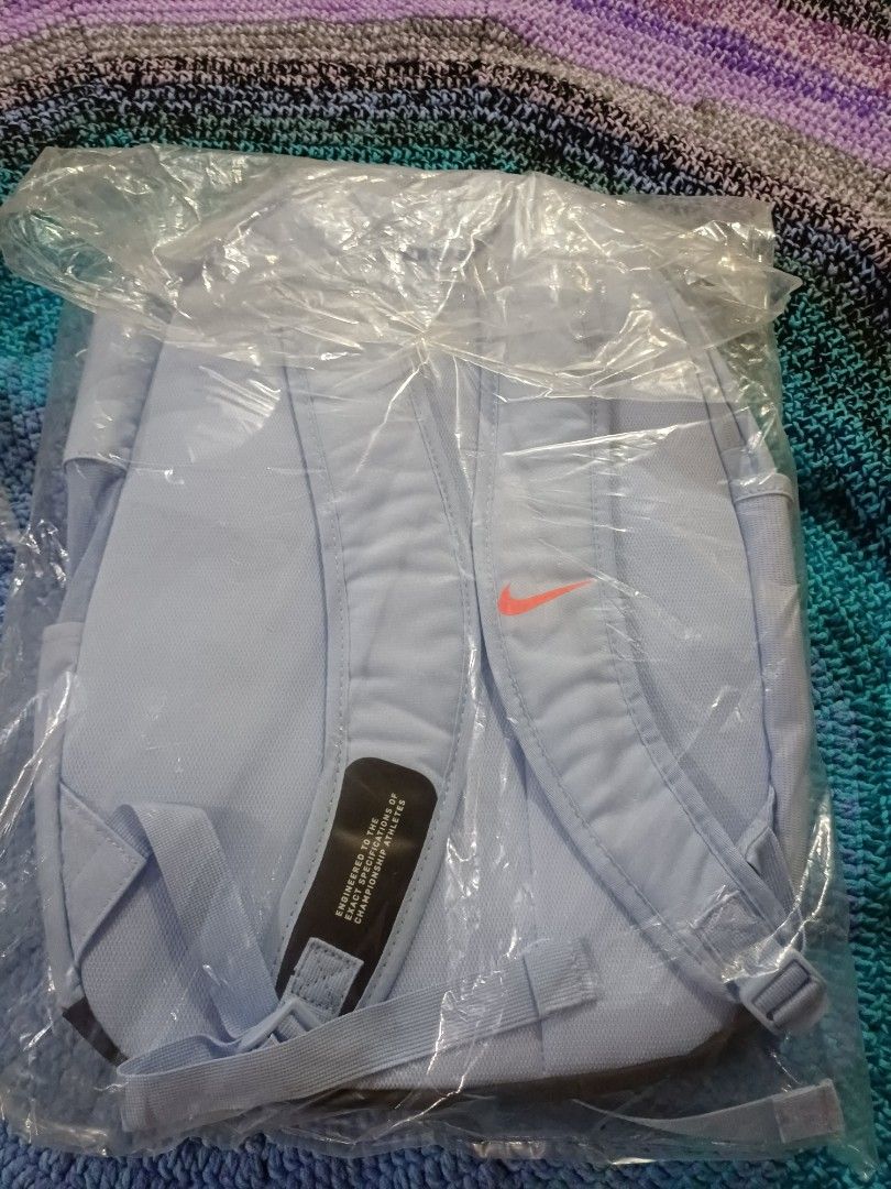 Nike Academy Backpack Light Blue with Geometric Pattern (Category: Backpacks) located in San Pedro. Submitted by purpledream0316 (Listing ID 1466502651, Image 2). Description: - Brand new and 100% authentic Nike backpack - Still sealed in original factory plastic packaging with tags attached - Color: Light blue with a stylish geometric front panel and black accents - Features a striking bright orange Nike swoosh logo on the back - Equipped with c