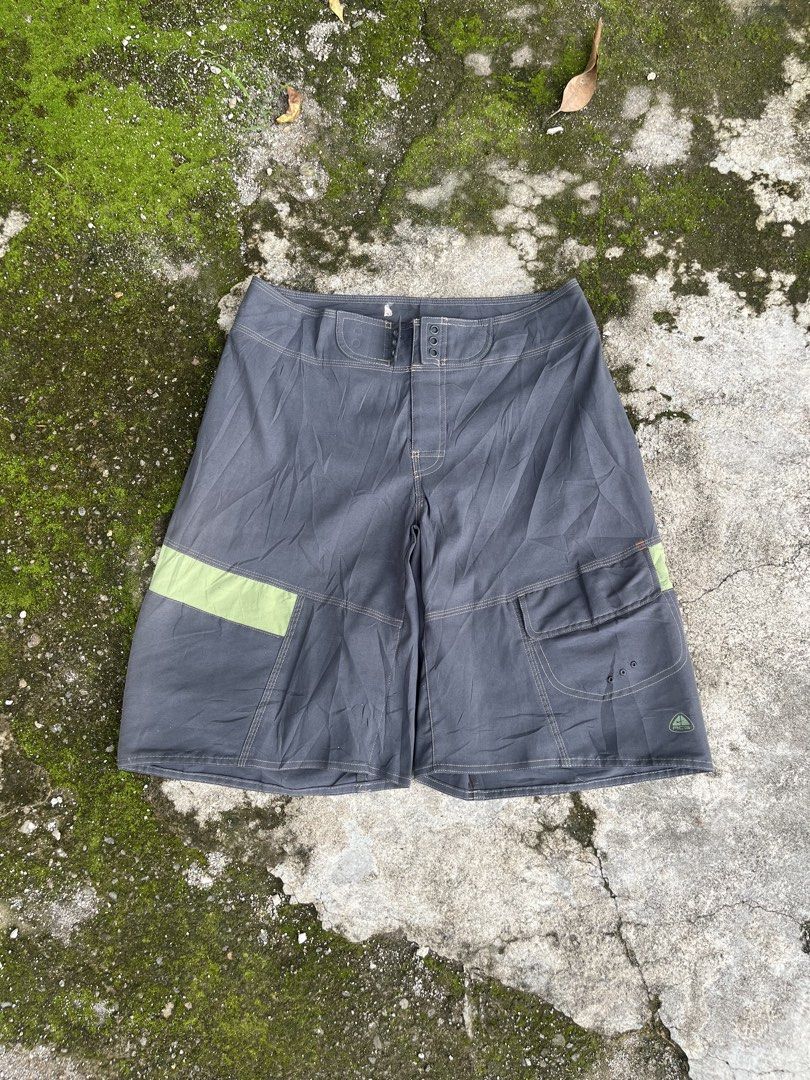 Nike ACG Cargo Boardshorts Grey Green (Category: Shorts) located in San Isidro, Leyte. Submitted by tigerxdx3580077 (Listing ID 1466414072, Image 1). Description: - Brand: Nike ACG - Waistline: 31to34 - Length: 22 - Color: Dark grey with muted green contrast panels - Features: Multiple utility pockets on the right leg with drainage grommets - Branding: Printed All Conditions Gear logo on the lower back leg - Closure: Button fly - Ideal for: Outdo