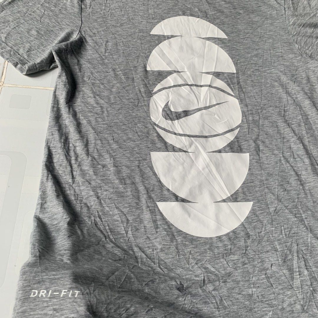 Nike Dri-Fit Grey Graphic Tee Size S (Category: Tshirts & Polo Shirts ) located in Daraga. Submitted by vinteesfnds (Listing ID 1466390901, Image 3). Description: - Brand: Nike Dri-Fit - Color: Grey with white abstract basketball graphic - Size: S Men - Size: M women - Material: 58% cotton, 42% polyester blend - Condition: Clean, with light wrinkles from folding - Style: Short sleeves, crew neck.