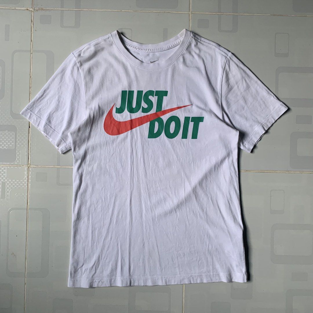 Nike Just Do It Graphic Tee White Size XS (Category: Activewear) located in Daraga. Submitted by vinteesfnds (Listing ID 1466393290, Image 1). Description: - Brand: Nike - NEED WASH - Color: White with green, red, and orange graphic - Design: Classic 'Just Do It' text over a large orange swoosh - Size: XS (tag printed inside the collar) - XS men , Medium Women - Material: 100% cotton - Fit: Regular fit, crew neck style - Condition: Excellent / Re