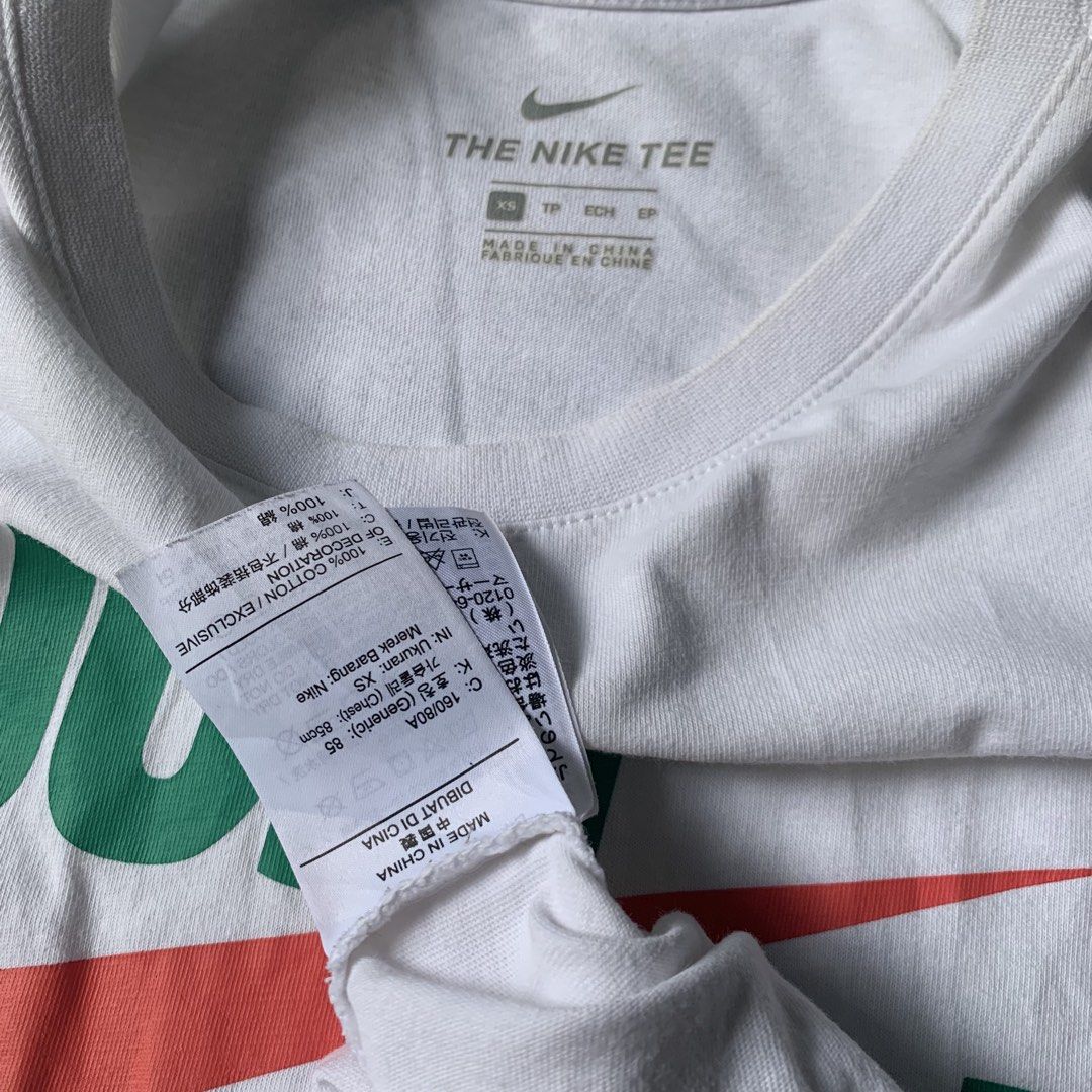 Nike Just Do It Graphic Tee White Size XS (Category: Activewear) located in Daraga. Submitted by vinteesfnds (Listing ID 1466393290, Image 3). Description: - Brand: Nike - NEED WASH - Color: White with green, red, and orange graphic - Design: Classic 'Just Do It' text over a large orange swoosh - Size: XS (tag printed inside the collar) - XS men , Medium Women - Material: 100% cotton - Fit: Regular fit, crew neck style - Condition: Excellent / Re