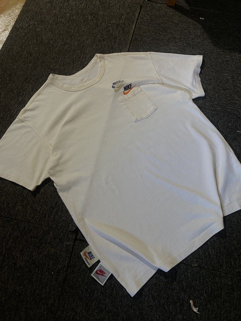 Nike White Pocket T-Shirt with Multi Logo (Category: Tshirts & Polo Shirts ) located in Antipolo. Submitted by japiiinorv30088 (Listing ID 1466434035, Image 1). Description: - White Nike t-shirt with a classic crew neck and short sleeves - Features a chest pocket with cool multi-color stacked Nike logo prints - Unique tag graphics located at the bottom hem - Perfect, versatile piece for everyday casual wear - Send a message for inquiries or fast 