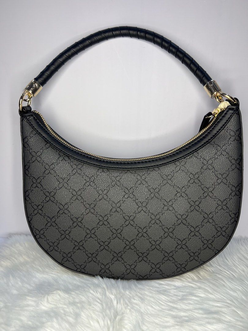 Nine West Black Pattern Crescent /hoboShoulder Bag (Category: Shoulder Bags) located in Quezon City. Submitted by gigisantos (Listing ID 1466504341, Image 2). Description: - Brand: Nine West - Style: Black crescent shoulder bag with structured faux leather - Design: All-over monogram pattern with chic gold hardware accents - Closure: Secure top zip closure - Straps: Single rolled shoulder strap with metal clasps - Interior: Includes a handy zippe