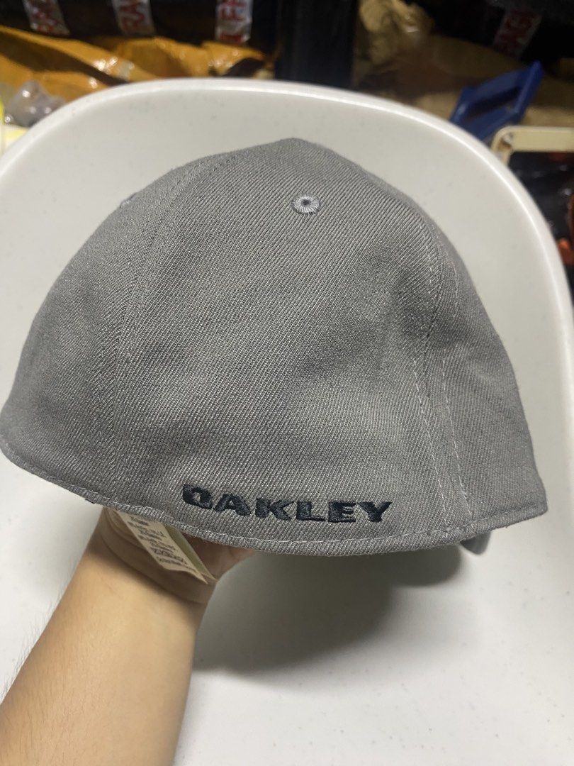 Oakley Classic Low A-Flex Cap Grey L/XL (Category: Caps & Hats) located in Pasacao. Submitted by wengpullar37205 (Listing ID 1466482952, Image 2). Description: - Brand: Oakley - Color: Grey with silver metal ellipse logo on front and black embroidered branding on back - Size: L/XL (A-Flex stretch-fit design) - Material: Comfortable acrylic, wool, and elastane blend - Design: Structured crown, curved brim, and branded interior taping - Condition: 